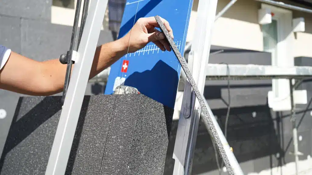 Découpe d'une bande de polystyrène graphité au fil chaud sur le chantier